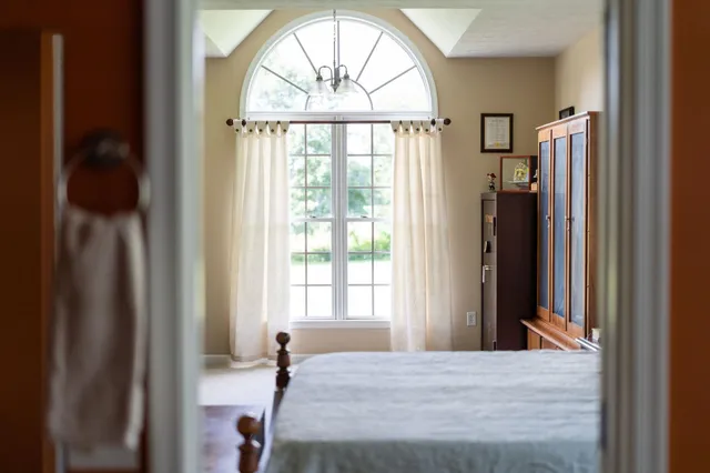 a bedroom with a bed and a large window