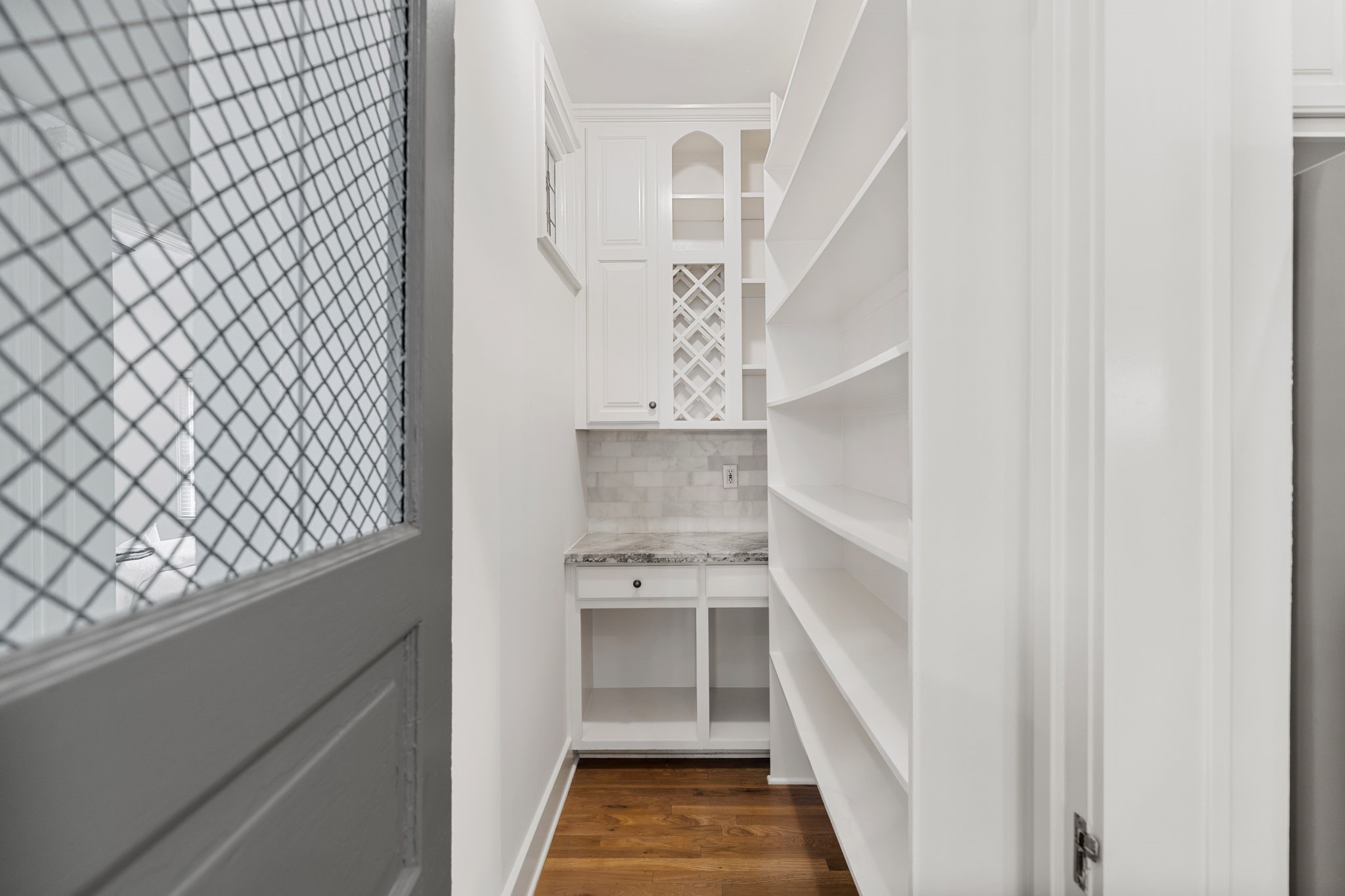 307 East 8th Street Houston, TX 77007 - Photo 13 of 35 The charming pantry door opens to reveal the walk in pantry featuring open shelving, an appliance shelf, generous countertop space, and charming stained-glass accent window