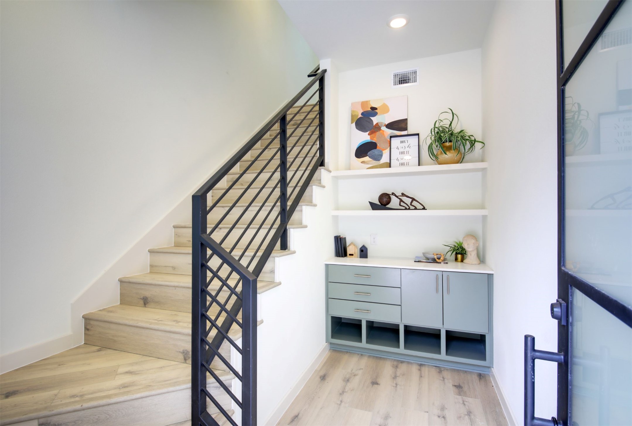 6802 Montana Street, Unit 2 Austin, TX 78741 - Photo 2 of 13 Clean lines define this bright entry, showcasing light wood flooring and a modern metal stair railing.