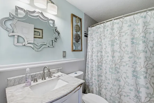 a bathroom with a sink vanity mirror and toilet