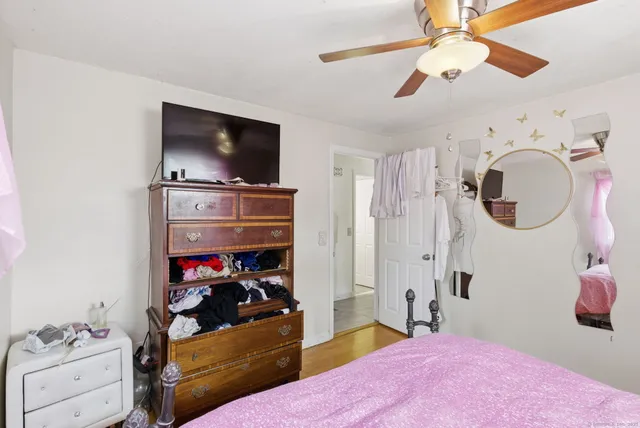 a bedroom with a bed and a flat tv screen on the dresser