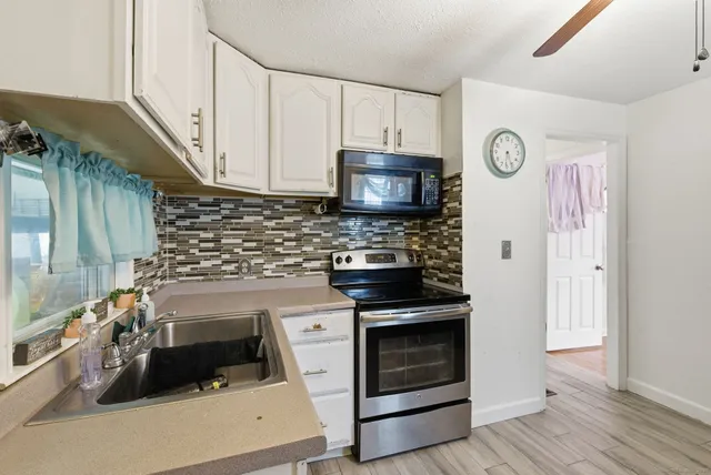 a kitchen with stainless steel appliances a stove a sink and a microwave
