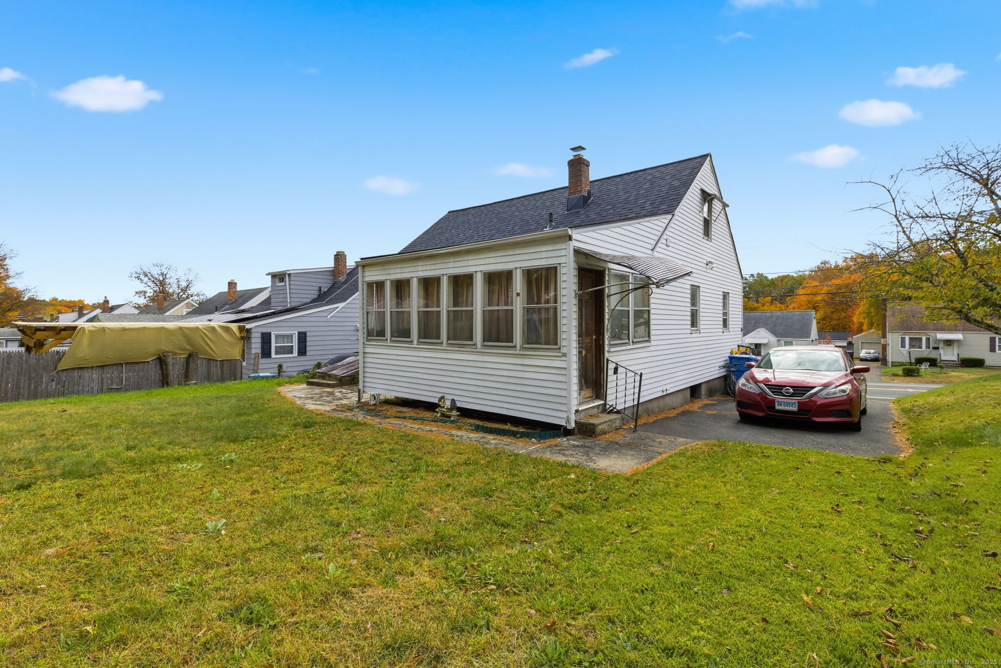 55 Alexander Road New Britain, CT 06053 - Photo 28 of 38 a white house that has a small yard and couches chairs with wooden fence