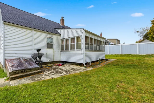 a front view of house with yard and trees in the background