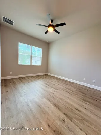 wooden floor in an empty room with a window