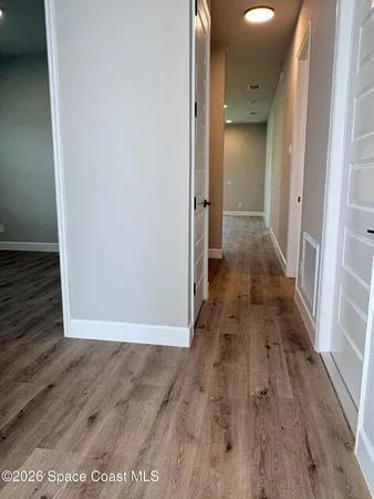 a view of a hallway with wooden floor