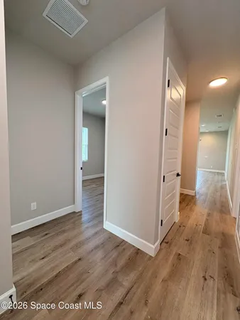 an empty room with wooden floor and a bathroom