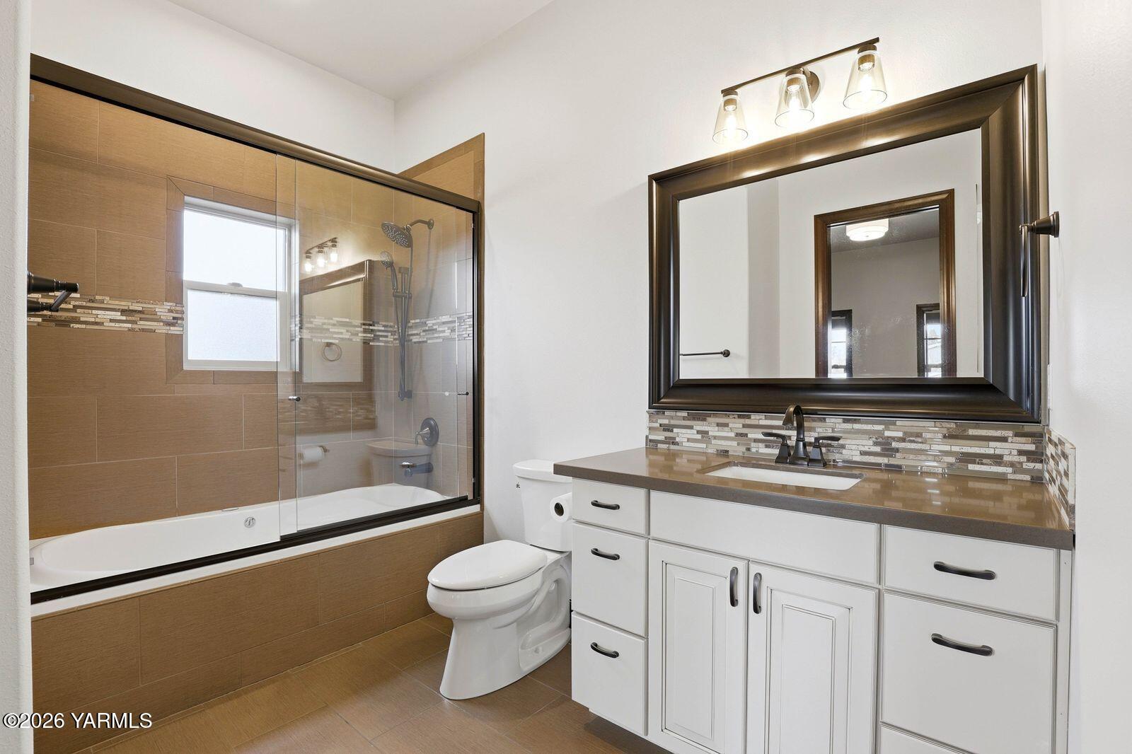 13507 West Church Road Yakima, WA 98903 - Photo 14 of 46 a bathroom with a granite countertop sink toilet a mirror and shower