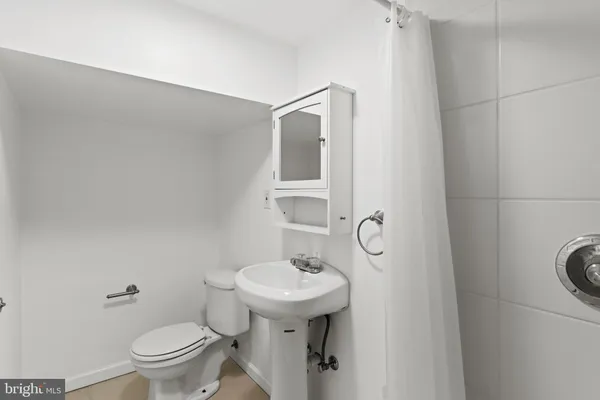 a bathroom with a granite countertop sink toilet and a mirror