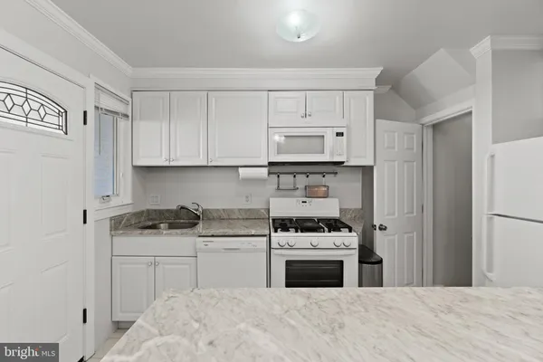 a kitchen with stainless steel appliances a white stove top oven and cabinets