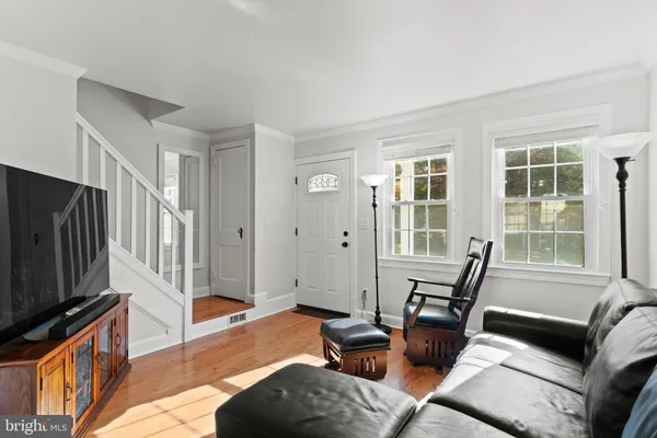 a living room with furniture a flat screen tv and a window