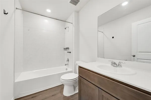 a bathroom with a tub shower vanity and sink