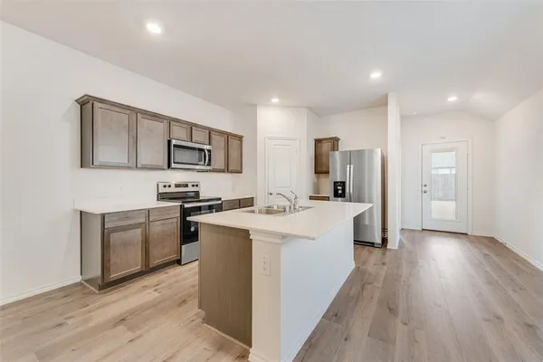 a kitchen with a sink stove and refrigerator