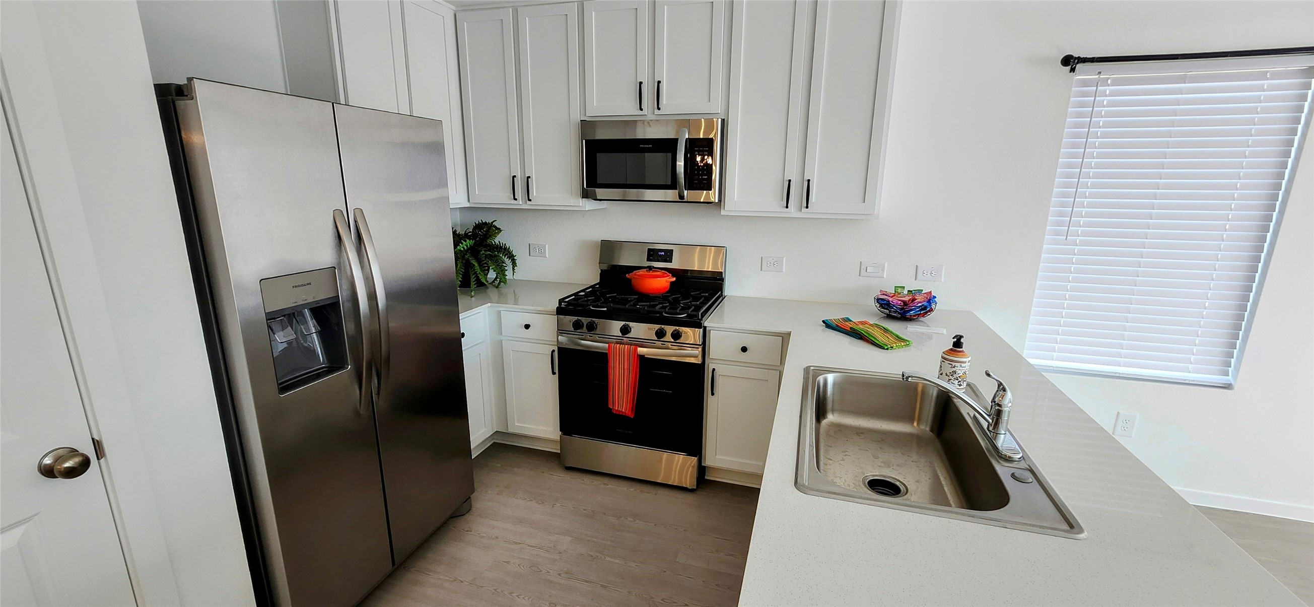 10288 Prairie Dunes Lane Cleveland, TX 77327 - Photo 4 of 15 a kitchen with stainless steel appliances a refrigerator a stove a microwave and cabinets