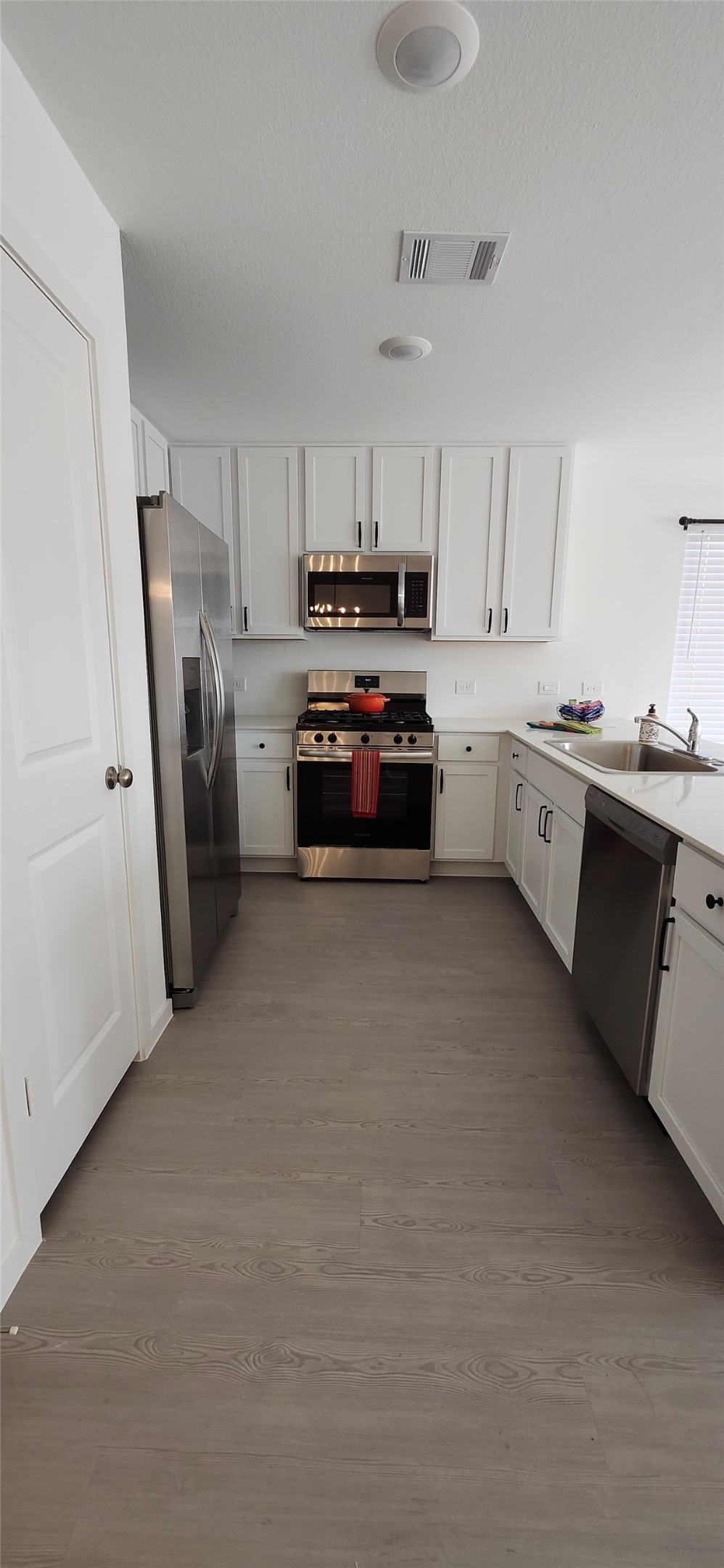 10288 Prairie Dunes Lane Cleveland, TX 77327 - Photo 5 of 15 a kitchen with refrigerator a sink and white cabinets
