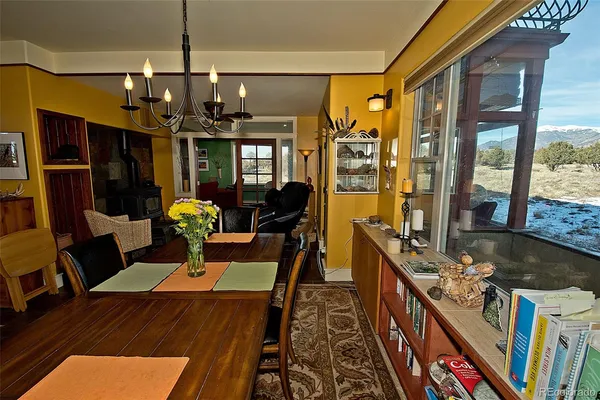 a view of a dining room with furniture a chandelier and wooden floor