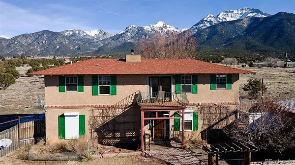 a view of house with a yard and a floor to ceiling window