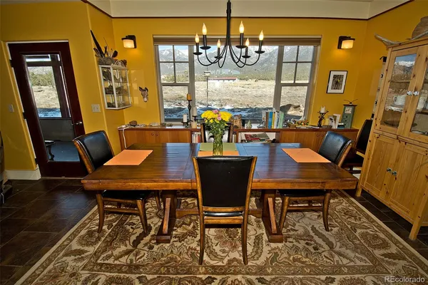 a view of a dining room with furniture a chandelier and wooden floor