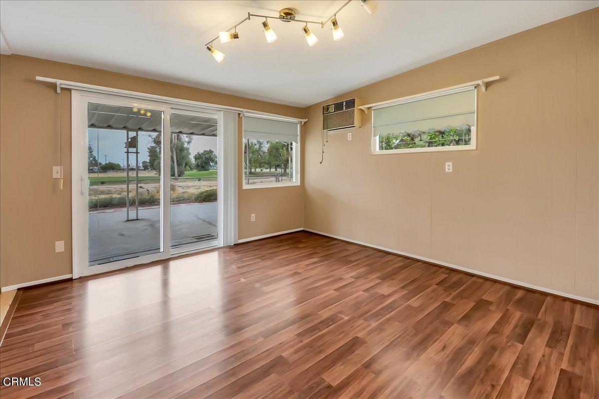 26204 Ridgemoor Road Menifee, CA 92586 - Photo 16 of 35 a view of an empty room with wooden floor and a window