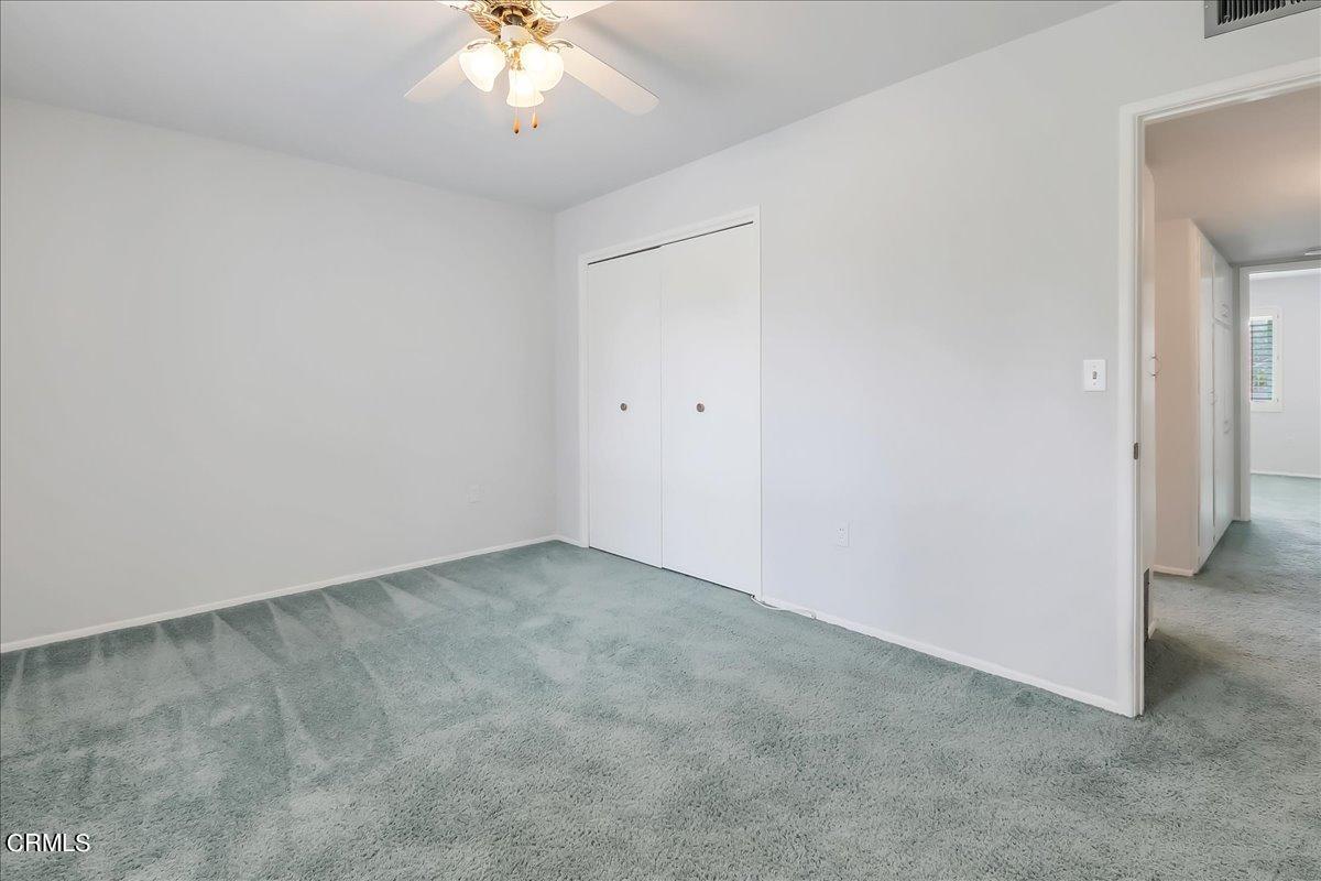 26204 Ridgemoor Road Menifee, CA 92586 - Photo 28 of 35 an empty room with a chandelier fan and windows