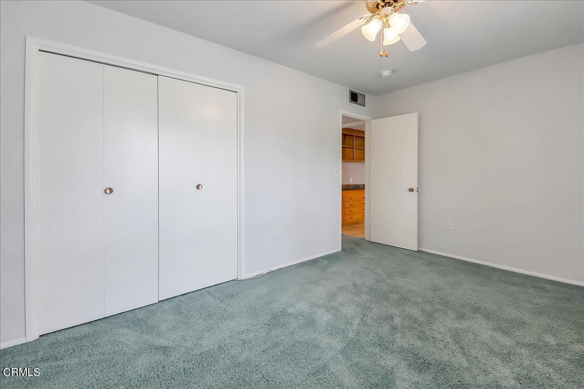26204 Ridgemoor Road Menifee, CA 92586 - Photo 29 of 35 an empty room with a chandelier fan and closet in a room
