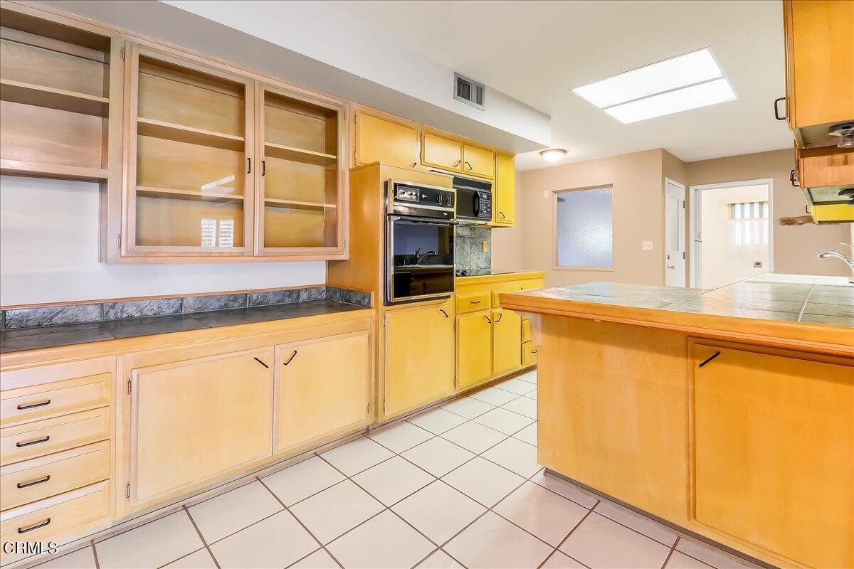 26204 Ridgemoor Road Menifee, CA 92586 - Photo 10 of 35 a large kitchen with granite countertop a sink and white cabinets