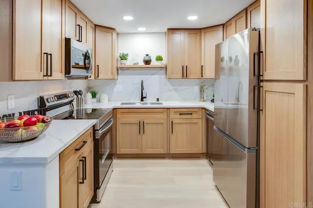 a kitchen with stainless steel appliances granite countertop a sink stove and refrigerator