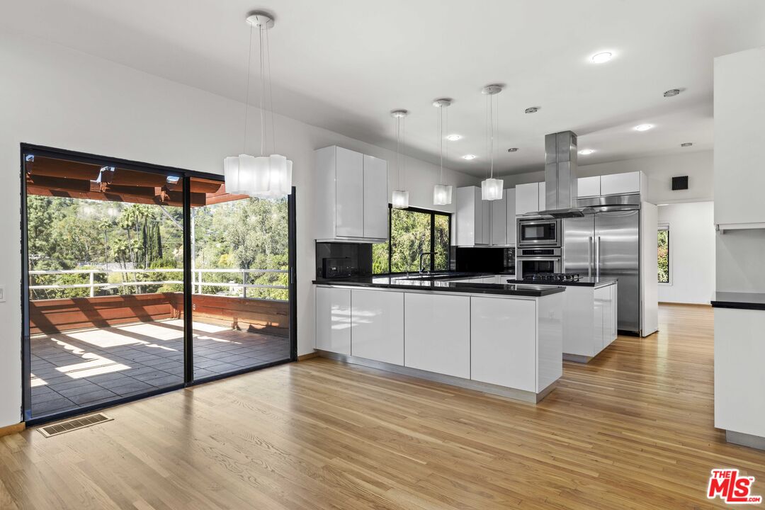 3275 Buckingham Road Glendale, CA 91206 - Photo 18 of 33 a large kitchen with stainless steel appliances kitchen island a large counter top and a wooden floors