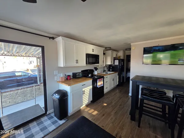 a kitchen with kitchen island granite countertop a stove top oven a sink and cabinets
