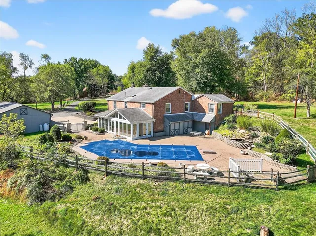 a aerial view of a house with a big yard and large trees