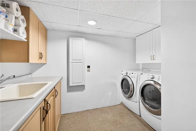 a utility room with sink dryer and washer