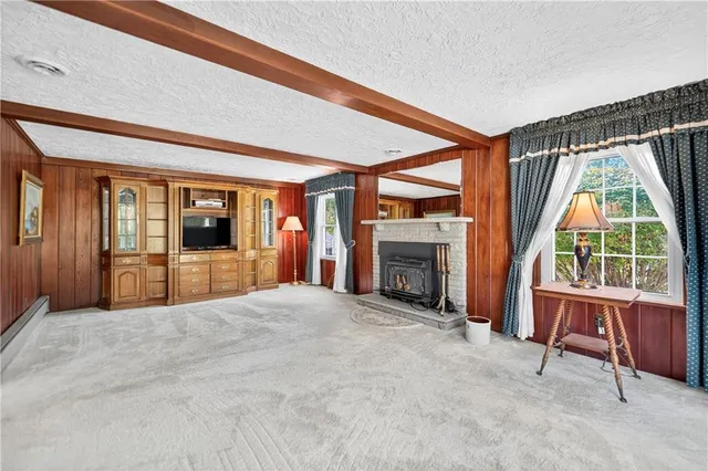 a view of an empty room with a fireplace and a window