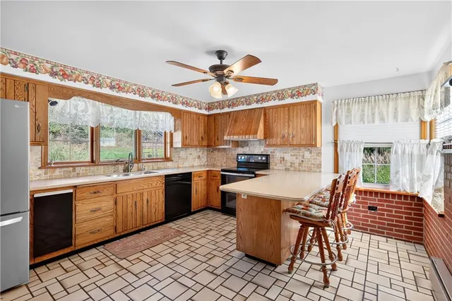 a kitchen with stainless steel appliances a dining table chairs and a refrigerator