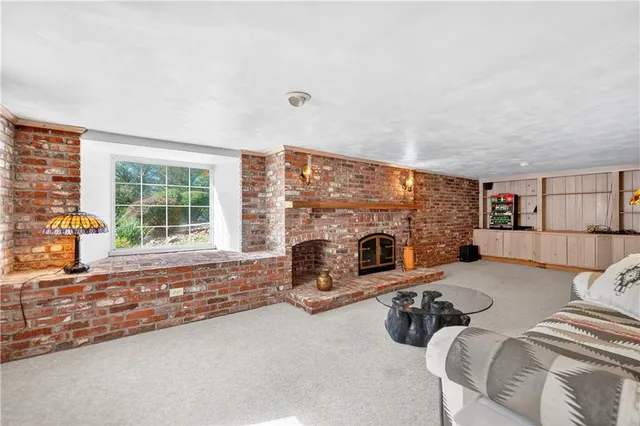 a living room with furniture large window and a fireplace
