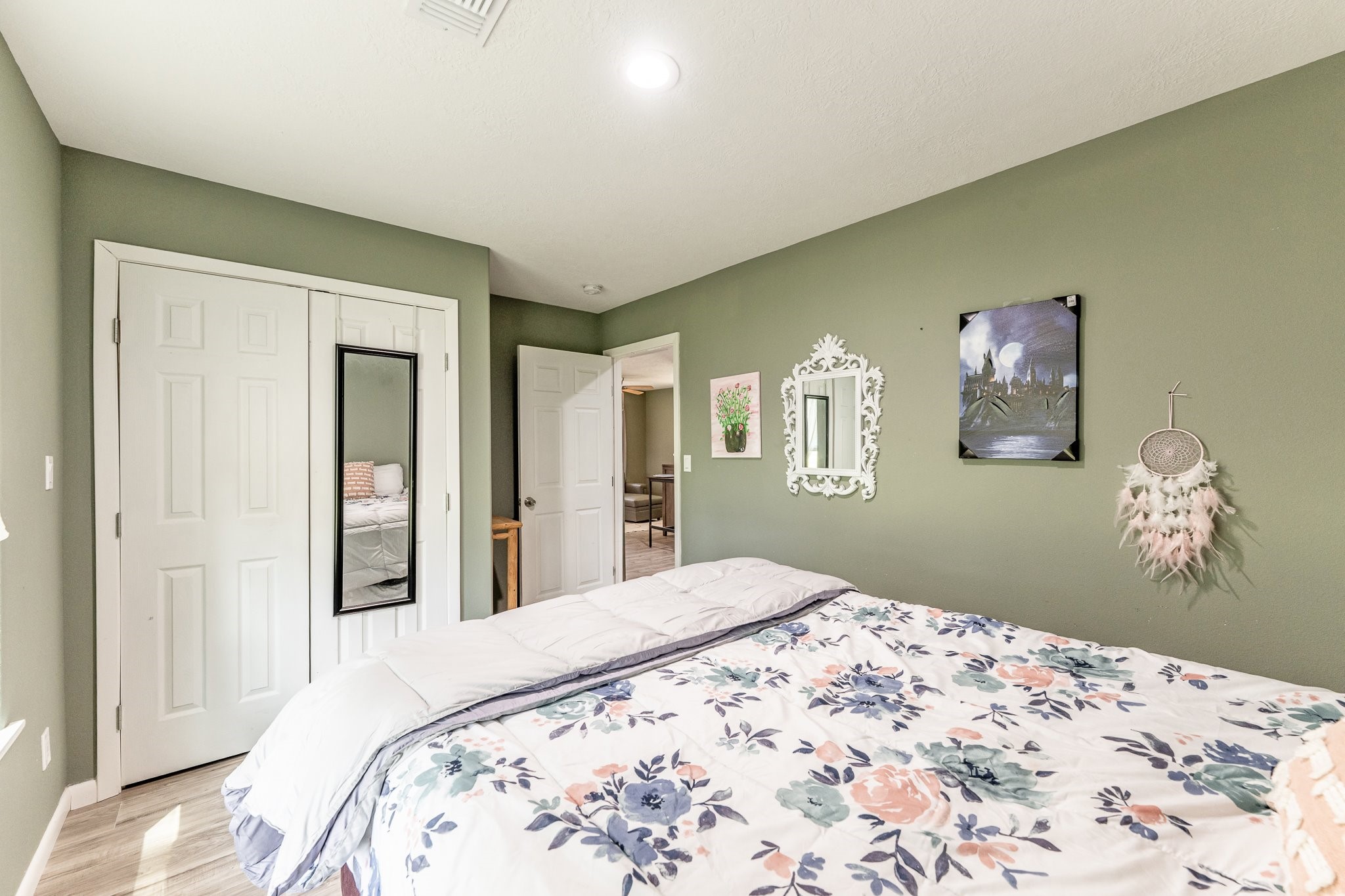 109 Monica Street Trinity, TX 75862 - Photo 21 of 32 a bedroom with a large bed and a chandelier