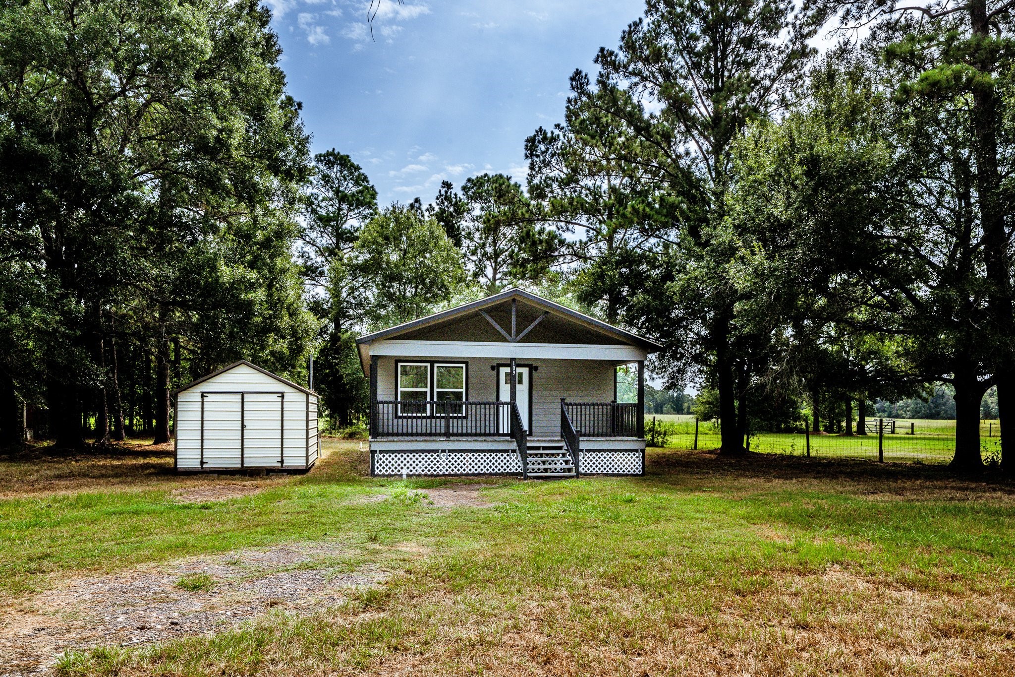 109 Monica Street Trinity, TX 75862 - Photo 31 of 32 a front view of a house with a garden and trees