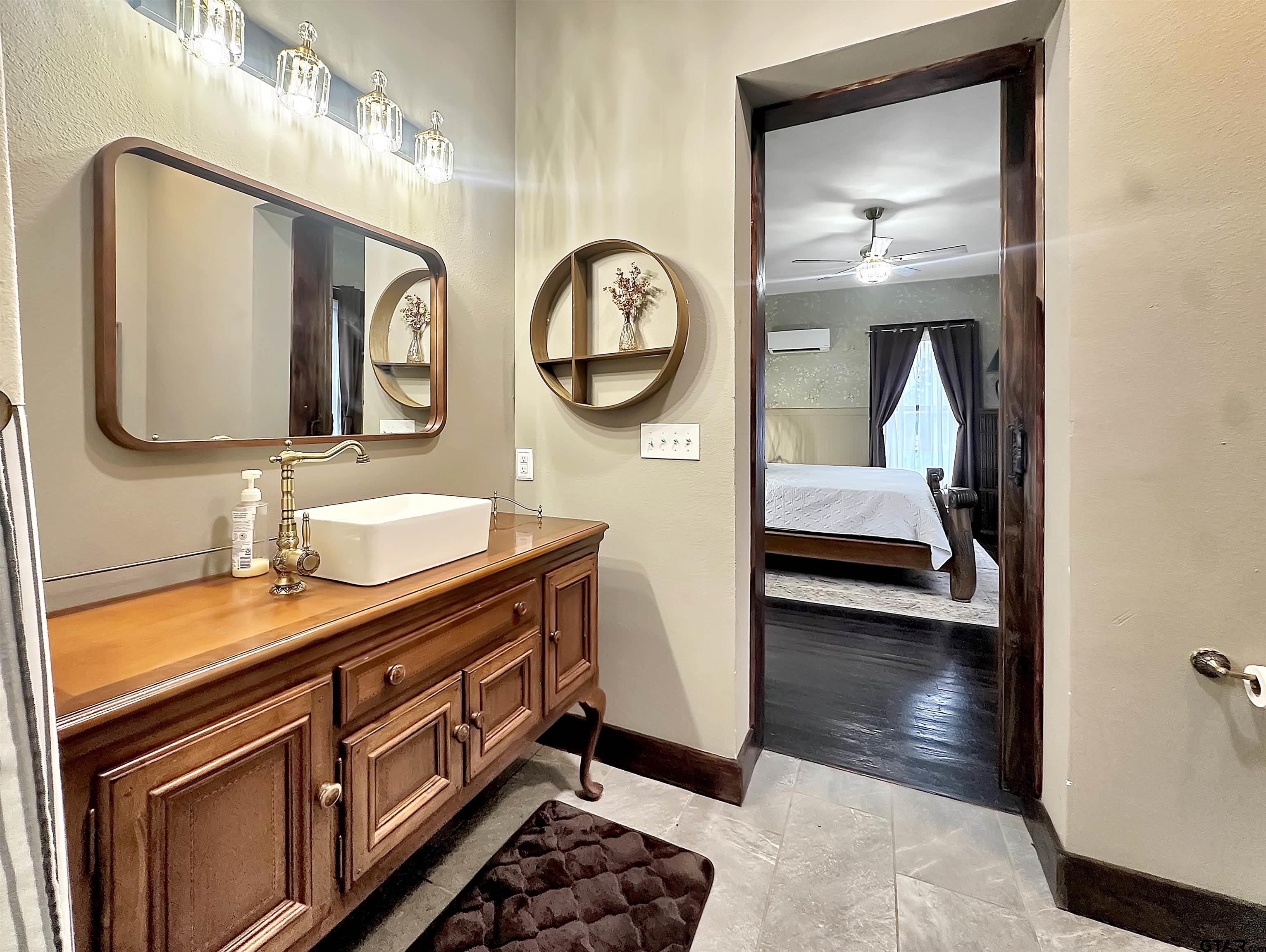 406 West 1st Street Mount Pleasant, TX 75455 - Photo 22 of 43 a en suite bathroom with a double vanity sink and a mirror