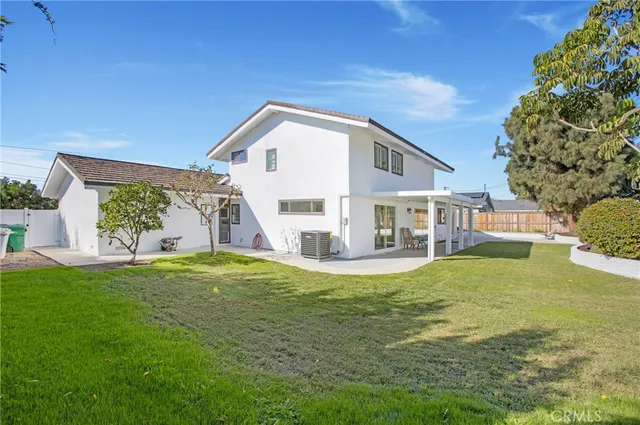 a view of a house with a big yard and potted plants