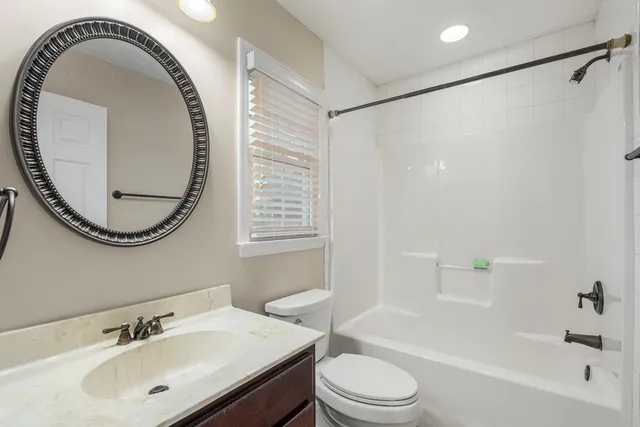 a bathroom with a sink a toilet and a mirror