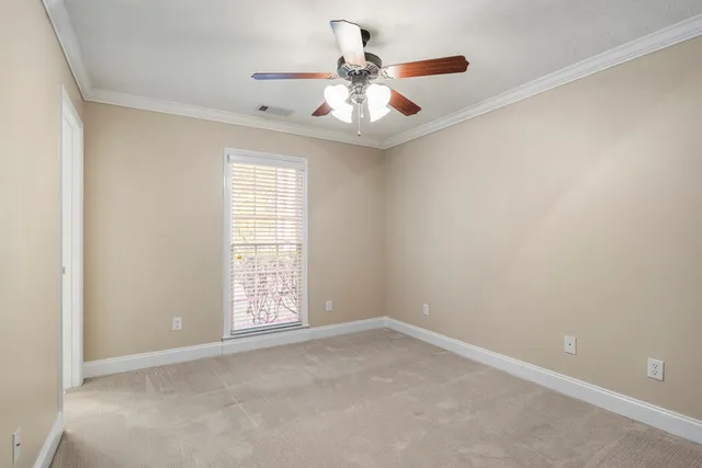 an empty room with a ceiling fan and window