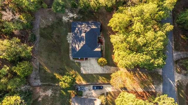 a aerial view of a house with a yard and large trees