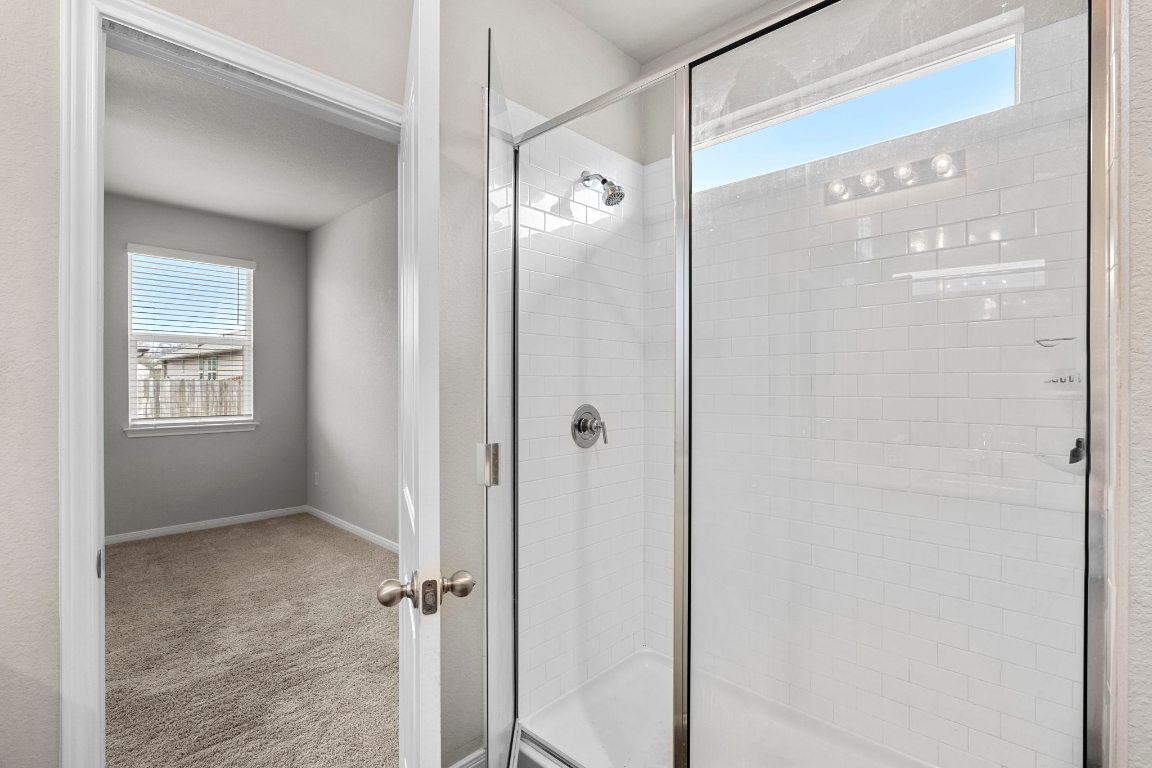 453 Apache Plum Drive Kyle, TX 78640 - Photo 14 of 30 a bathroom that has a glass shower door