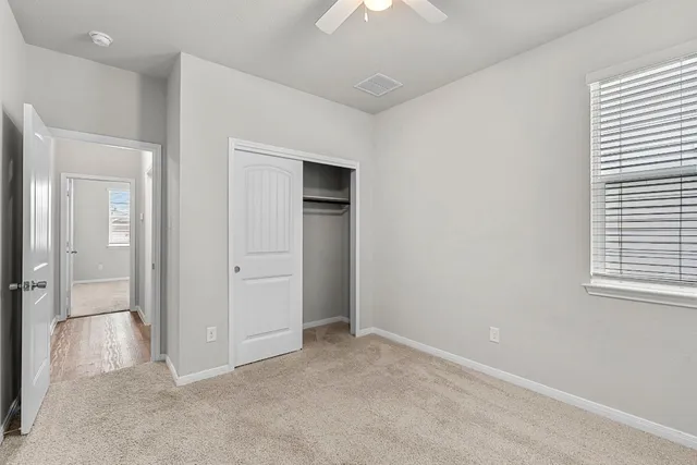 an empty room with windows and closet