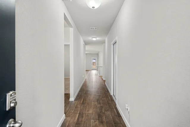 a view of a hallway with wooden floor
