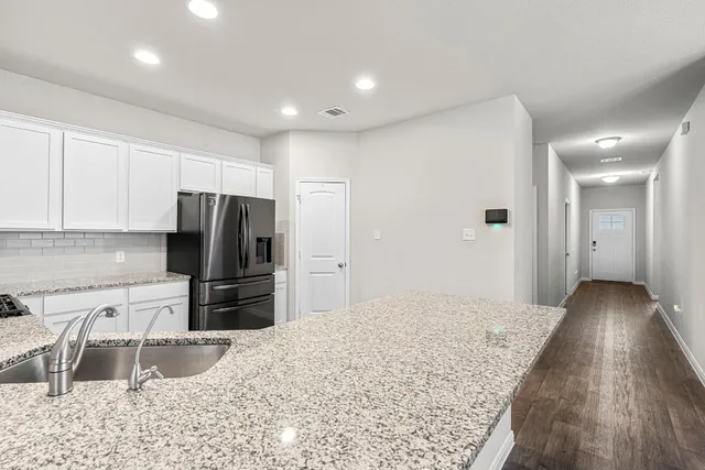 a kitchen with a refrigerator and a sink