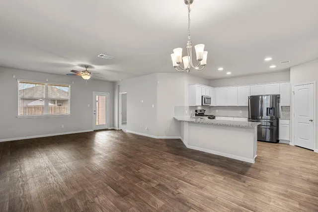 a view of a kitchen with stove and wooden floor