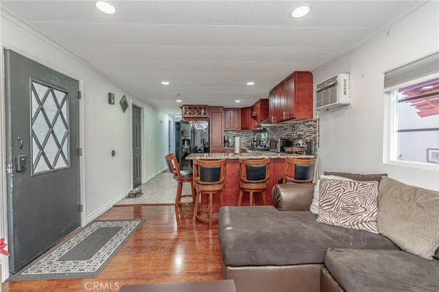 a living room with stainless steel appliances kitchen island granite countertop furniture and a rug
