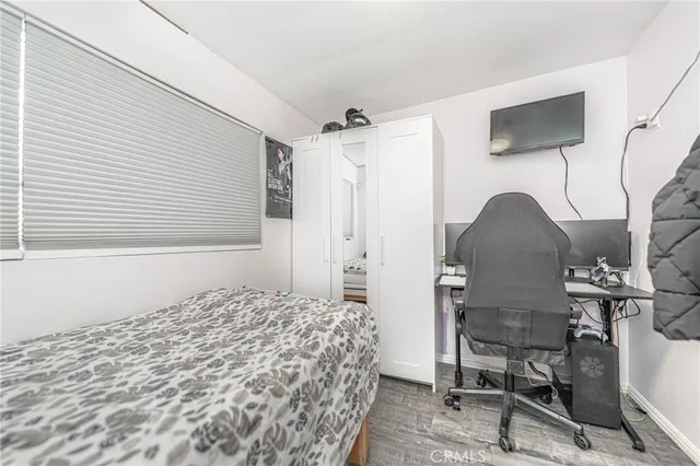 a bedroom with a bed a chair and a flat screen tv