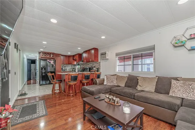 a living room with furniture kitchen view and a window