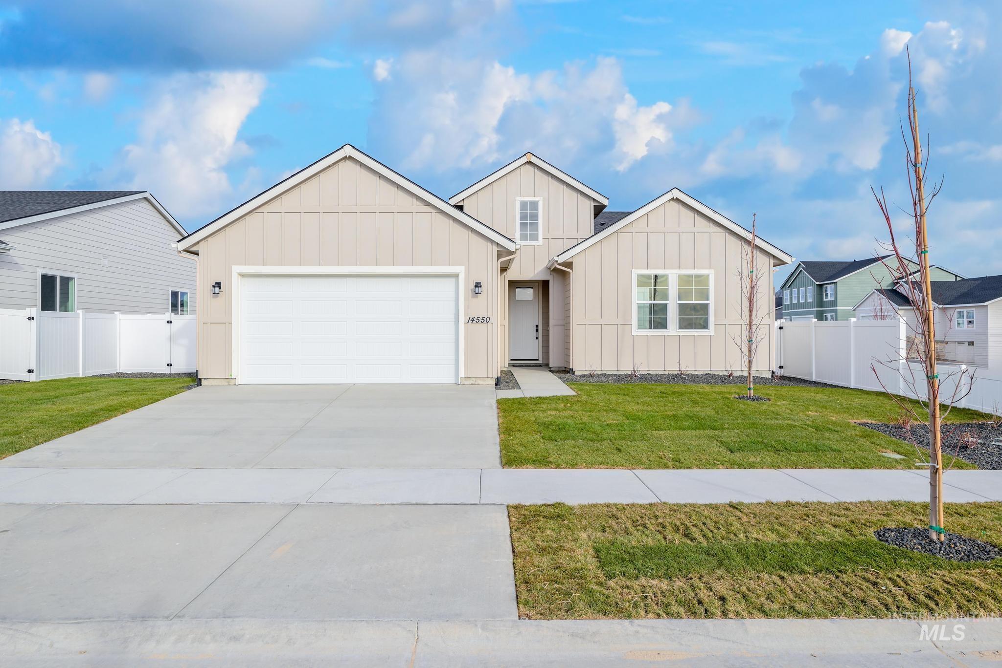 View of front facade featuring board and batten siding, driveway, and an attached garage